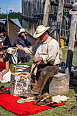 A man in period mountain man dress shows how to make leather Native American moccasins at the Fort Bridger Rendezvous in Wyoming.