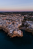Luftaufnahme der Skyline von Polignano a Mare bei Sonnenuntergang, Apulien, Italien