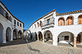 Mendos Arch offers a charming pathway to Plaza Mayor, showcasing the beauty of Garrovillas de Alconetar under a clear blue sky.