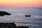Fishing boat at sunset in Polignano a Mare, Puglia, Italy