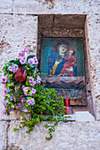 Catholic shrine in window with candles and flowers, Monopoli, Italy
