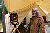 A photographer in period dress with a vintage tintype camera at the Fort Bridger Historic Site in Wyoming during the Fort Bridger Rendezvous.