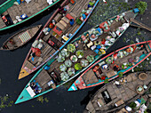 Dhaka, Bangladesh - 19 May 2025: Aerial view of a vibrant market along the Buriganga River with traditional boats and people selling fresh vegetables and fruit, Dhaka Kotwali Thana, Dhaka, Bangladesh.