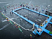 Trakai, Lithuania - 01 March 2025: Aerial view of winter swim competition on a frozen lake with swimmers and spectators, Trakai, Trakai, Lithuania.