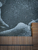 Aerial view of frozen lake with abstract patterns and a wooden pier, Trakai, Trakai, Lithuania.