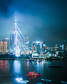 Aerial view of a beautiful urban skyline with modern skyscrapers and a river reflecting city lights at night, Hongkou, Shanghai, People's Republic of China.