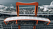 Split, Kroatien - 28. April 2024: Luftaufnahme der freitragenden Plattform des Magic Carpet auf dem Kreuzfahrtschiff Celebrity Beyond, eine leuchtend orangefarbene Struktur vor dem weiten, tiefblauen Meer.