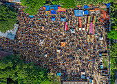Aerial view of a bustling fair with vibrant stalls and crowds of people, a tapestry of colors and activity under the sun, Mahasthan, Rajshahi Division, Bangladesh.