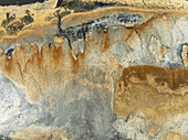 Aerial view of mineral deposits creating a textured landscape with gold, gray, and black hues, resembling abstract art, Walvis Bay, Erongo region, Namibia.