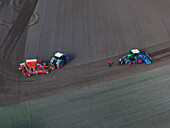 Aerial view of tractors working the field, a scene of rural industry unfolding in the landscape of Bralitz, Bad Freienwalde, Brandenburg, Germany.