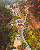 Luftaufnahme der Kawazu-Nanadaru-Schleifenbrücke, die sich durch üppig grüne Hügel und Täler schlängelt, ein modernes Wunderwerk im Kontrast zur zeitlosen Schönheit der Natur, Kawazu, Shizuoka, Japan.