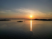 Luftaufnahme der Sonne, die die Adria küsst und das Wasser mit goldenen Farbtönen färbt, während die Inseln friedlich schlummern, Biograd na Moru, Gespanschaft Zadar, Kroatien.