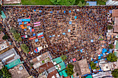 Aerial view of a densely packed crowd with colorful tents and flags creates a vibrant tapestry of human activity, Mahasthan, Rajshahi Division, Bangladesh.