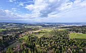 Luftaufnahme von grünen Wäldern und malerischen Dörfern unter einem weiten Himmel, eine Symphonie aus Grün und Braun, die sich bis zum Horizont erstreckt, Angenofen, Steiermark, Österreich.