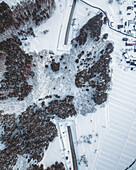 Aerial view of a winter wonderland where snow-laden trees meet icy roads, a stark contrast under the crisp, cold sky, Niijukuchiku, Yamagata, Japan.