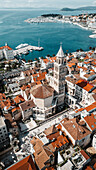 Luftaufnahme der Kathedrale des Heiligen Domnius, die sich majestätisch inmitten eines Meeres von Terrakotta-Dächern erhebt und mit der azurblauen Adria kontrastiert, Split, Gespanschaft Split-Dalmatien, Kroatien.