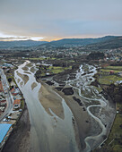 Aerial view of Ramallosa Roman Bridge over the meandering Minor River with picturesque village and serene mountains, Baiona, Pontevedra, Spain.