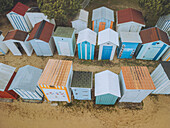 Aerial view of colourful beach huts along the sandy shore at Plage de la Boirie, Saint-Denis-d'Oleron, Charente-Maritime, France.