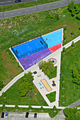 Aerial view of a vibrant playground with sports courts and greenery, Marzahn, Berlin, Germany.