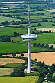 Aerial view of a tranquil landscape featuring a transmission antenna amidst green fields and meadows, Kleinwolstrup, Schleswig-Holstein, Germany.