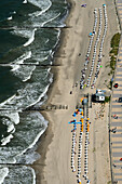 Aerial view of sandy beach with umbrellas and beach chairs along the coastline, Ostseebad Kuhlungsborn, Mecklenburg-Vorpommern, Germany.