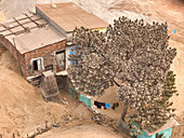 Aerial view of a sand pit and rustic houses surrounded by trees in a dusty environment, Dhaka, Dhaka, Bangladesh.