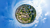 Aerial view of a tiny planet perspective of residential buildings and greenery under a cloudy sky, Reussbuhl, Lucerne, Switzerland.