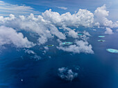 Luftaufnahme von wunderschönen tropischen Inseln, umgeben von klarem azurblauem Ozean und heiteren Wolken, Malediven, Malediven.