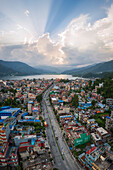 Aerial view of vibrant sunset over cityscape with mountains and lakeside, Shrikrishna Tol, Gandaki, Nepal.