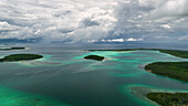 Aerial view of a beautiful tropical island with clear water and lush greenery, Western Province, Solomon Islands.