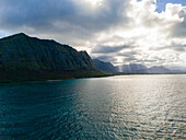 Aerial view of beautiful coastline with serene ocean and majestic mountains at sunrise, Waimanalo, Hawaii, United States.