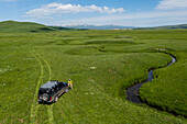 Nshkhark, Armenia - 28 May 2021: Aerial view of a person with a car near a stream of waters near fresh water springs, Nshkhark, Gegharkunik Province, Armenia.