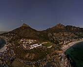 Aerial view of the majestic Lion's Head and Table Mountain embrace the cityscape, its beaches reflecting the soft twilight, Cape Town, Western Cape, South Africa.