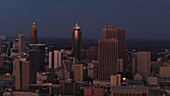 Atlanta, Vereinigte Staaten - 24. Juni 2025: Luftaufnahme von hoch aufragenden Wolkenkratzern, die den Dämmerungshimmel durchstoßen und deren goldene Fassaden das letzte Licht des Tages vor einer tiefblauen Leinwand reflektieren.