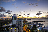 Aerial view of the city skyline fading into the tranquil bay waters as dusk paints the sky with soft hues, punctuated by the marina lights, Miami, Florida, United States.