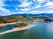 Aerial view of a medieval castle ruin standing proudly on an island surrounded by tranquil lake waters, a scene of history amidst nature's embrace, Pont-en-Ogoz, Fribourg, Switzerland.