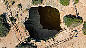 Luftaufnahme des dramatischen Einsturzlochs von Algar de Benagil, wo der Ozean in einem atemberaubenden Schauspiel der Naturgewalten auf die Erde trifft, Lagoa, Bezirk Faro, Portugal.