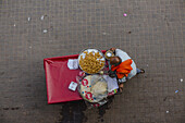 Agra, India - 24 June 2025: View of a street vendor seen from above, his cart a splash of red against the grey pavement, offering golden, fried snacks.