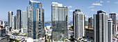 Luftaufnahme von glänzenden Wolkenkratzern, die den strahlend blauen Himmel durchdringen und den Ozean in ihren Glasfassaden widerspiegeln, Miami Arena sticht hervor, , Miami, Florida, Vereinigte Staaten.
