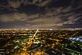 Aerial view of a vibrant city bathed in golden lights under a cloudy night sky, Miami, Florida, United States.