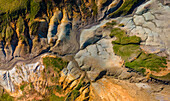 Luftaufnahme einer Landschaft, in der leuchtende Grüntöne auf erdige Braun- und Bräunetöne treffen, in einem strukturierten Bildteppich der Kunstfertigkeit der Natur, Grindavik, Grindav?kurb?r, Island.