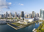 Luftaufnahme der strahlend weißen Struktur des Kaseya Centers, die sich von der azurblauen Uferpromenade und den hoch aufragenden Wolkenkratzern abhebt - ein lebhafter Kontrast unter dem klaren Himmel, Miami, Florida, Vereinigte Staaten.