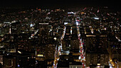 Aerial view of a cityscape illuminated by a tapestry of twinkling lights, revealing the urban sprawl and arteries of traffic, San Francisco, California, United States.