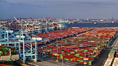 Long Beach, United States - 07 April 2025: Aerial view of the port's vibrant tapestry of cargo containers under towering cranes, reflecting the bustling energy of global trade.