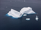 Aerial view of jagged icebergs, sculpted by wind and time, float in the dark, cold waters, a stark contrast of white and deep blue, Seymour Island, Antarctica.