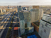 Aerial view of a modern architectural landscape where sleek skyscrapers contrast with the sprawling railway lines below, Amsterdam, North Holland, Netherlands.