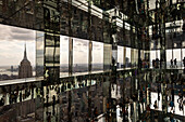 New York, United States - 07 June 2024: View of the Empire State Building framed by mirrored panels, reflecting crowds and the cityscape in a dazzling display of light and perspective.