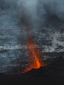 Luftaufnahme von feuriger Lava, die sich dramatisch von der dunklen, zerklüfteten Landschaft bei Grindavik abhebt, ein starker Kontrast unter einem düsteren Himmel, Grindavik, Region Südliche Halbinsel, Island.
