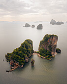 Aerial view of the iconic karst formations rising majestically from the emerald waters of Phang Nga Bay, creating a surreal and breathtaking seascape, Phang Nga Bay, Thailand.