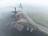 Aerial view of windmills shrouded in a mystical fog, alongside quaint buildings and boats, creating a serene, ethereal scene, Zaandam, Noord-Holland, Netherlands.